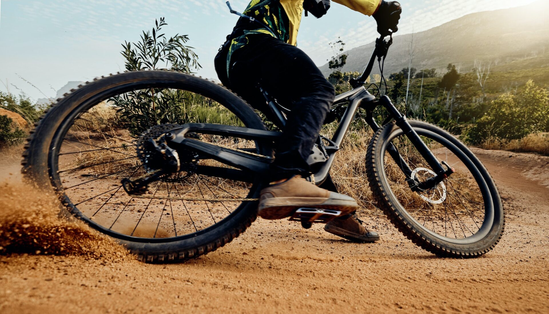 Sports, action and biker dirt racing on mountain bike enjoying riding, cycling and moving with spee